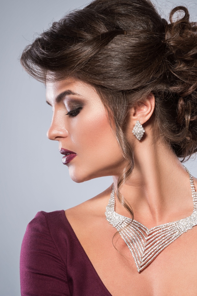 Стильная женщина с вечерней прической, макияжем и дорогими украшениями