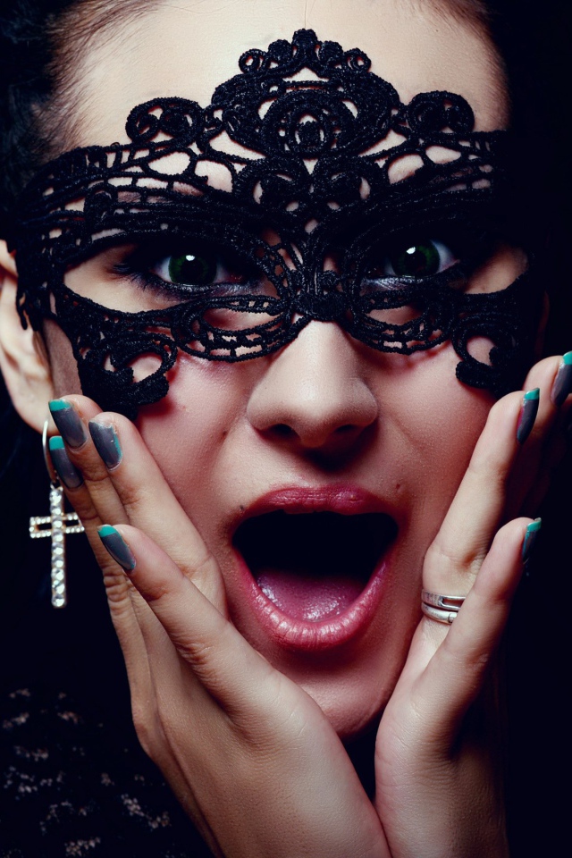 Удивленная девушка в черной маске на лице