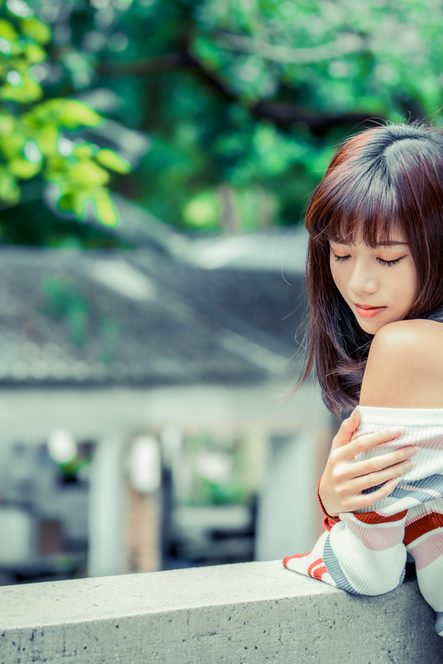 Нежная азиатка стоит на балконе