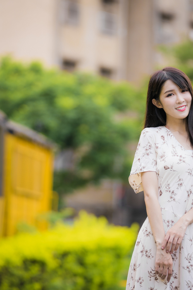 Нежная улыбающаяся азиатка в красивом платье 