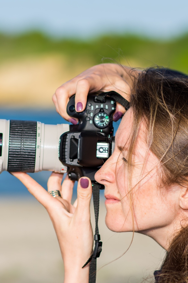 Девушкой делает фото на фотоаппарат 