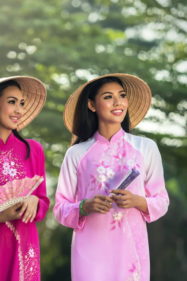 Две девушки азиатки в платьях с веером в руках