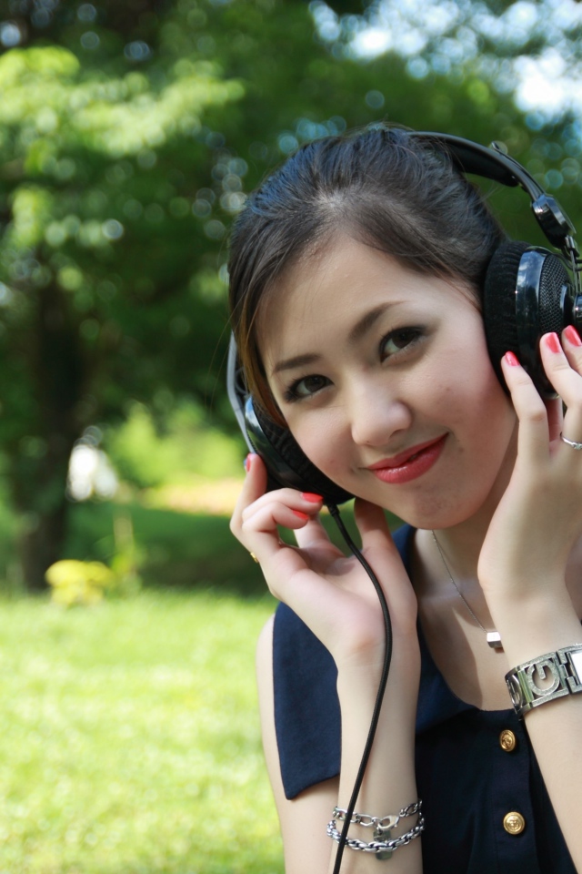 Молодая девушка азиатка в больших наушниках 