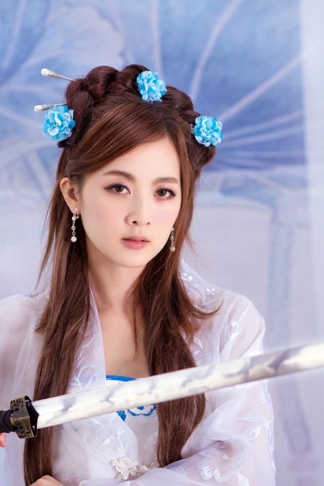 Молодая девушка азиатка с мечом в руках 