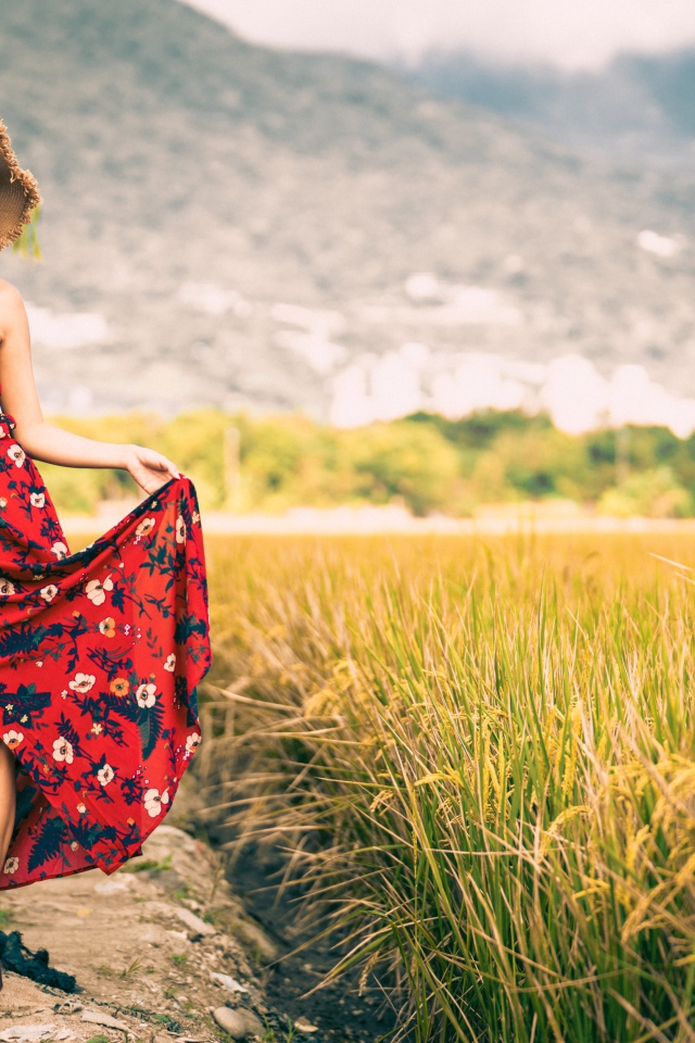 Молодая азиатка в сарафане на рисовом поле 