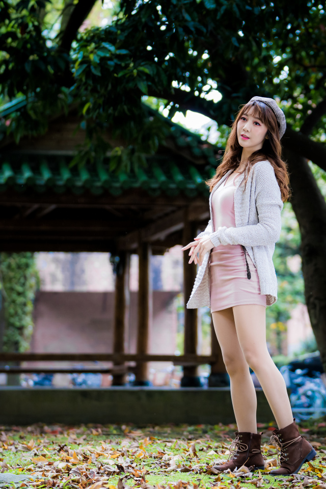 Молодая азиатка в теплой кофте в парке