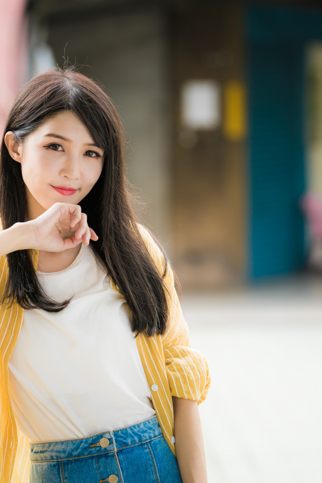 Молодая азиатка в белой майке и полосатой рубашке 