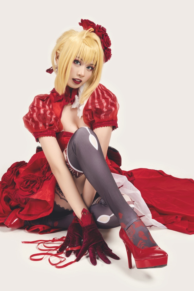 Молодая азиатка в ярком красном костюме на белом фоне