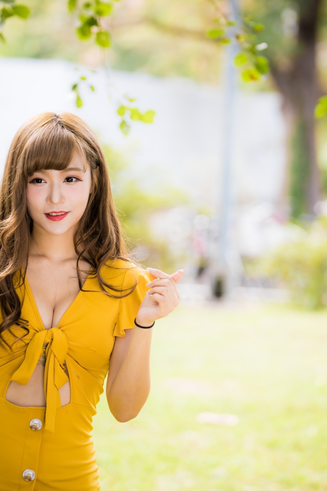 Молодая азиатка в желтом платье в парке