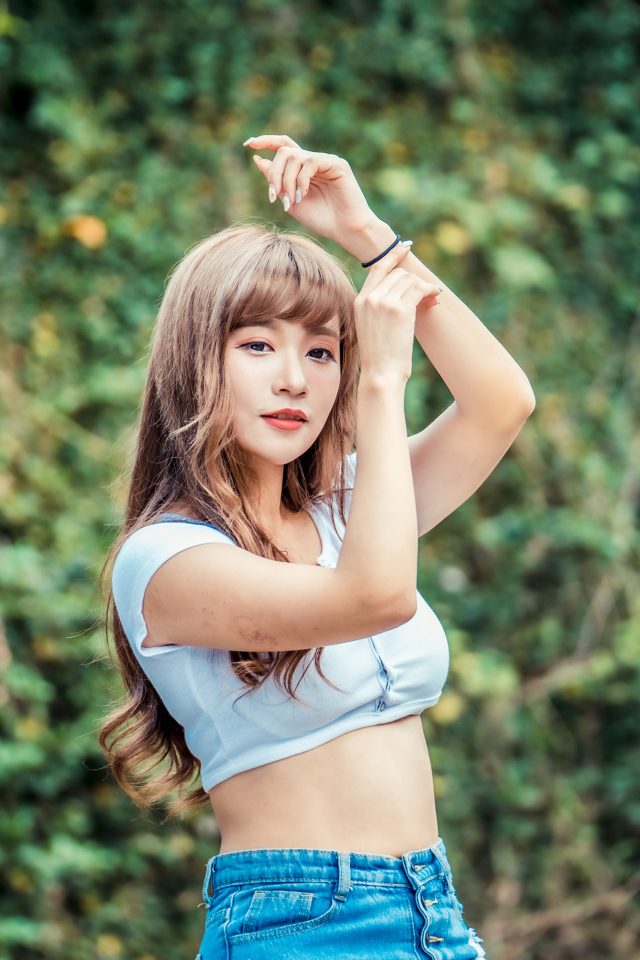 Молодая азиатка подняла руки вверх 