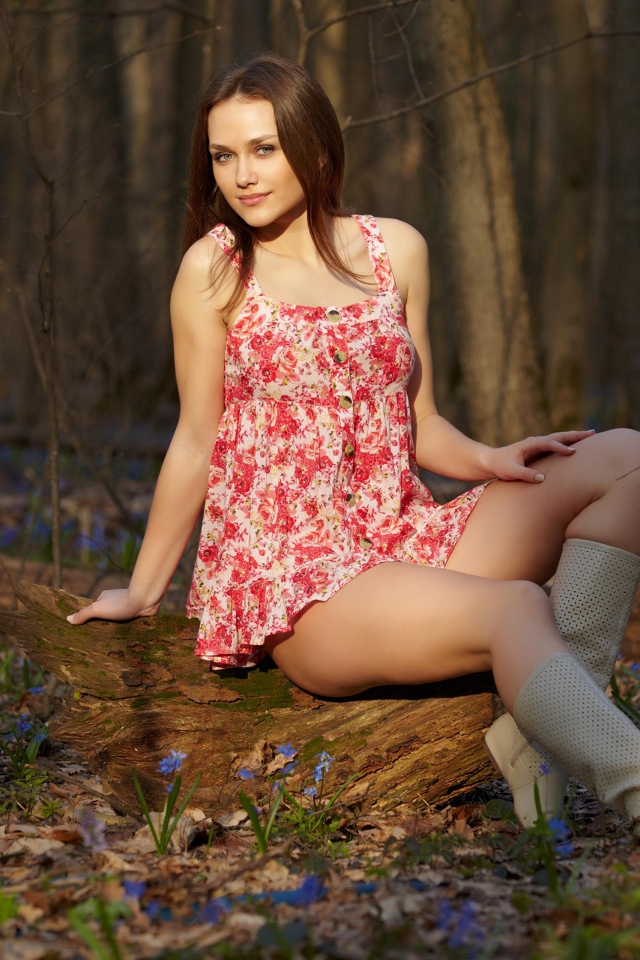 Young girl in a short dress in the spring forest.