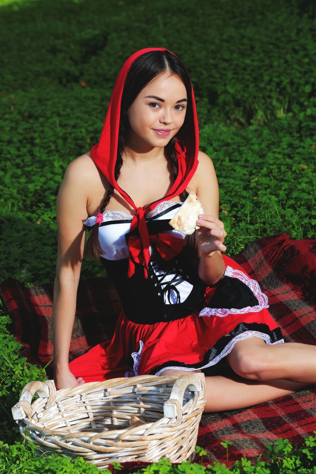 Молодая девушка в костюме сидит на траве, косплей