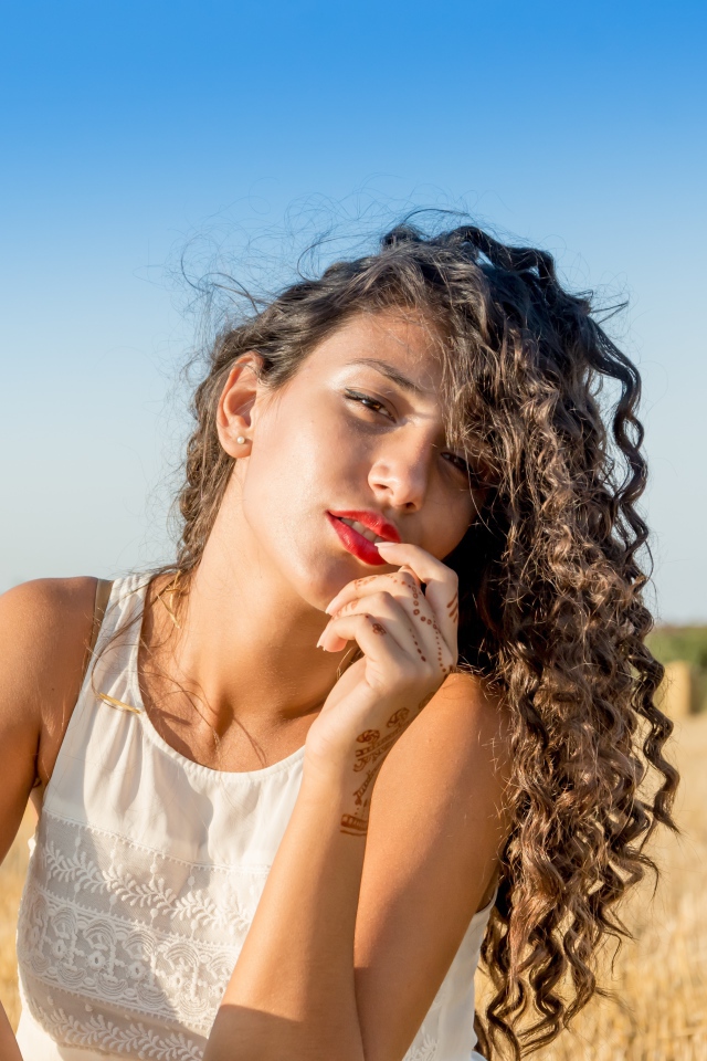 Молодая девушка в белом платье на пшеничном поле