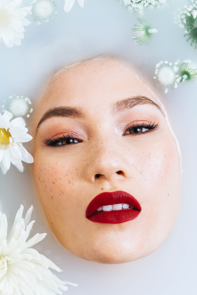 Молодая девушка лежит в ванной с цветами