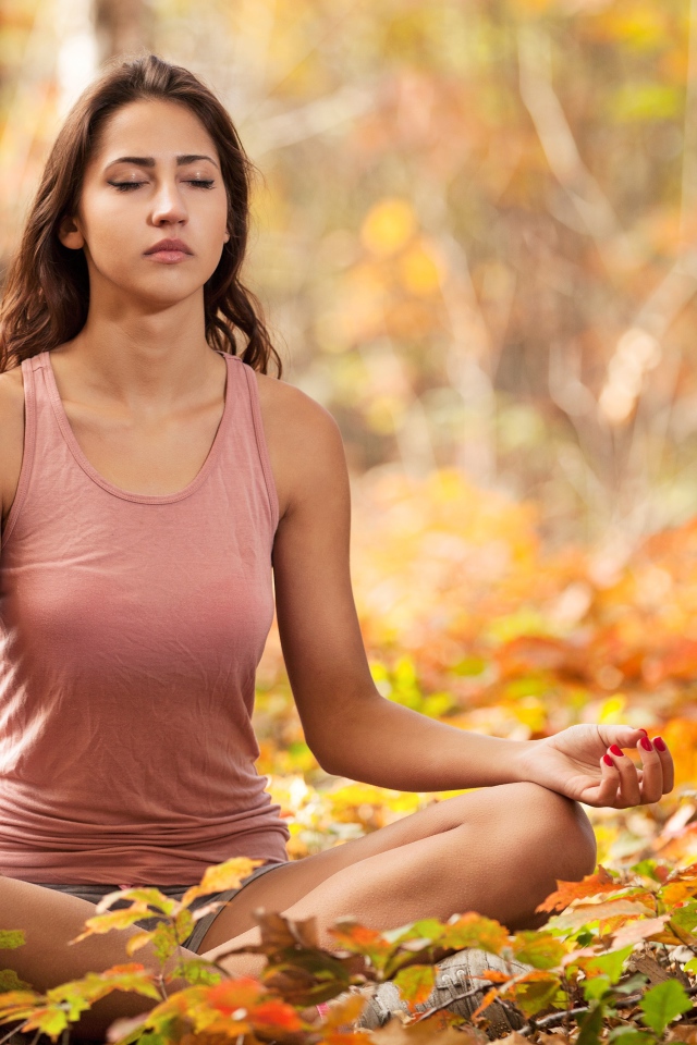 Молодая девушка медитирует в лесу 