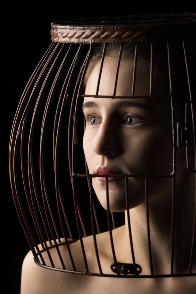 Молодая девушка с клеткой на голове 