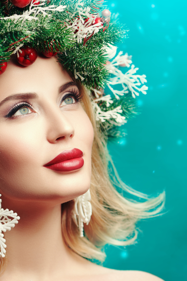 Красивая девушка с венком из еловых веток на голове на голубом фоне