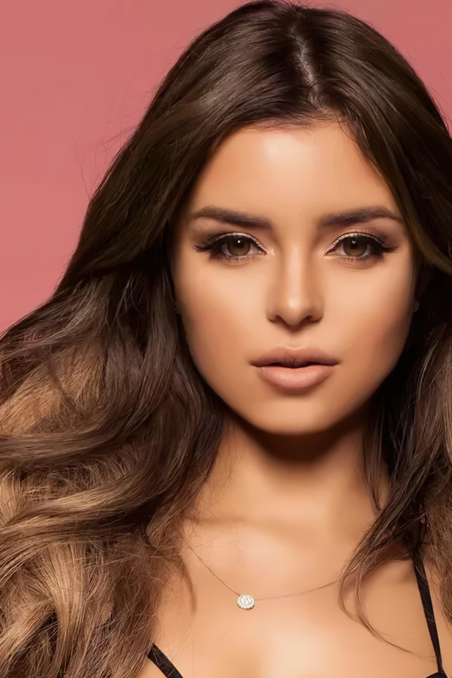 Beautiful long-haired model Demi Rose on a pink background