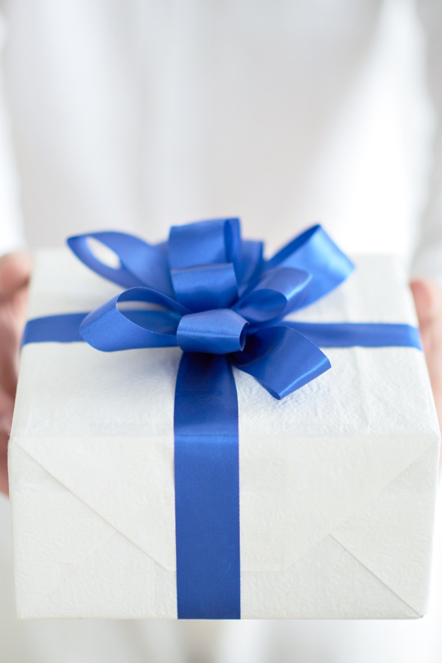 Gift with a blue bow in hands