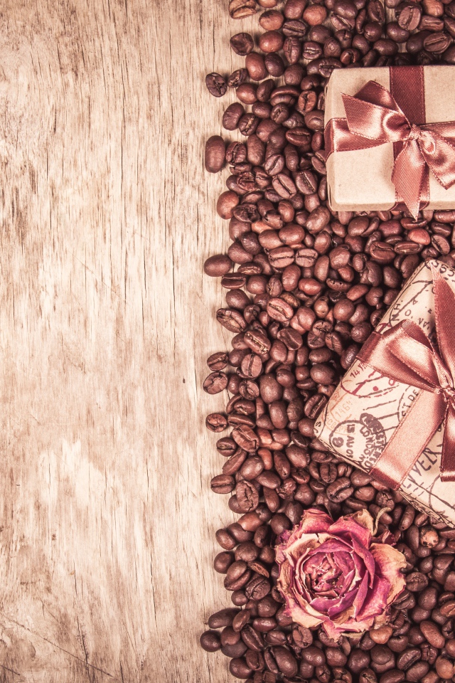 Подарки и розы лежат на кофейных зернах