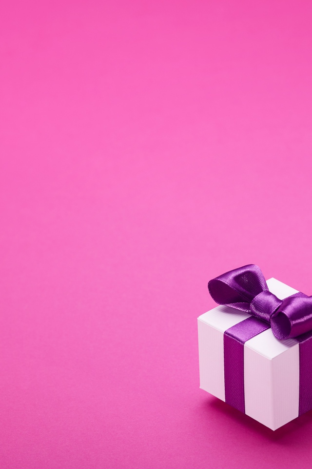 Two gifts with bows on a pink background