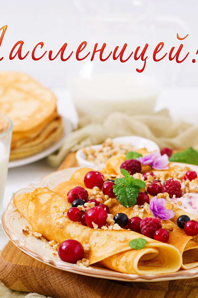 Тонкие блины на тарелке с ягодами на праздник Масленица