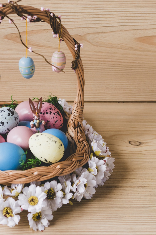 Корзинка с пасхальными яйцами украшена цветами