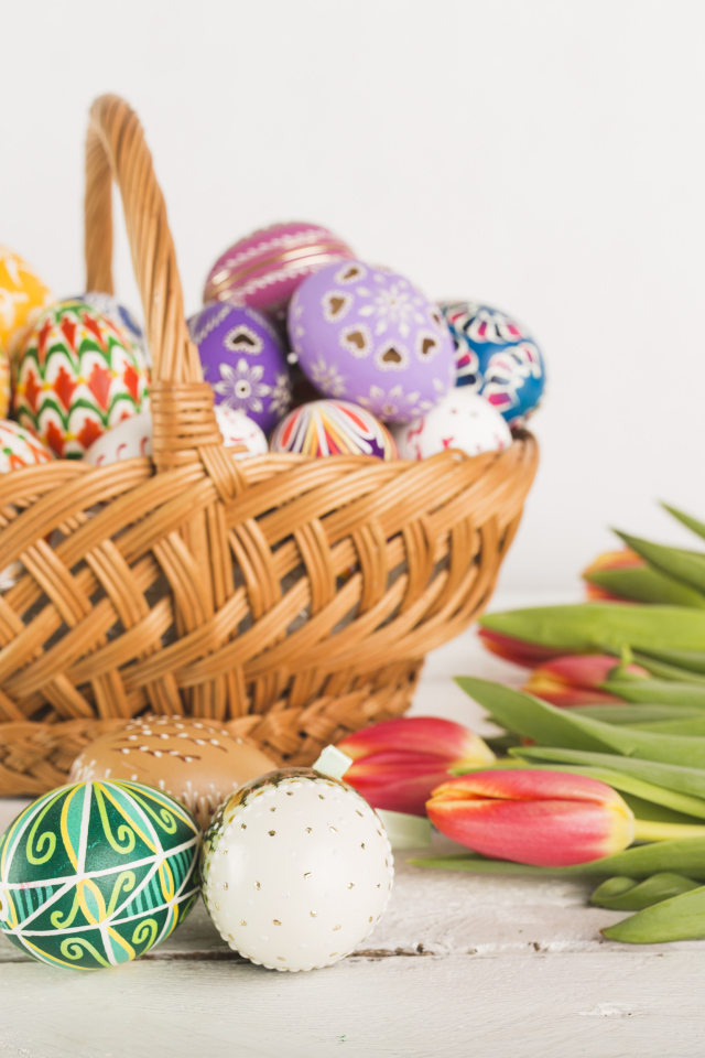 Корзинка с разноцветными яйцами и тюльпанами на Светлый праздник Пасха