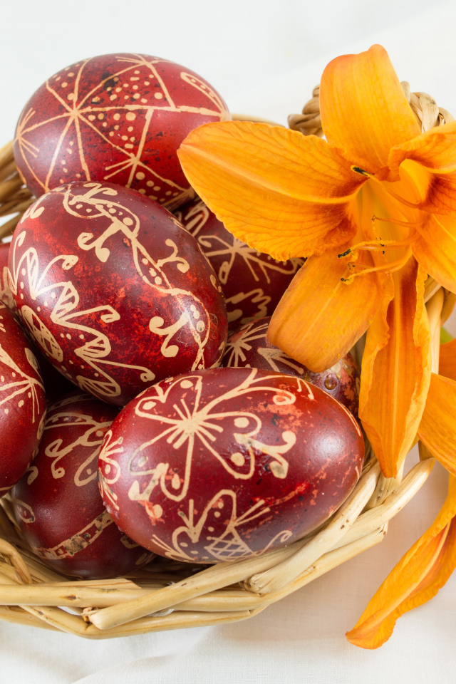 Красивые пасхальные яйца с цветами лилии в корзине