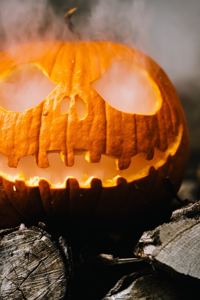 Желтая тыква с дымом на дровах на Хэллоуин