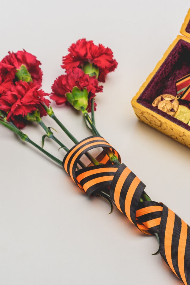 Букет гвоздик с георгиевской лентой и наградами на День Победы 9 мая