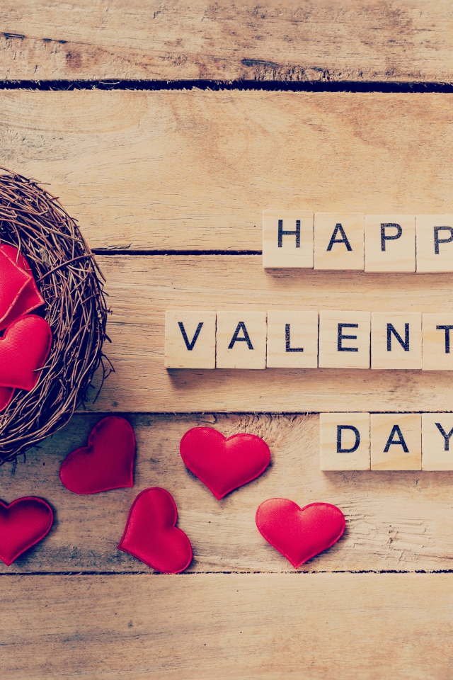 Кубики и гнездо с сердечками на деревянном столе на День Святого Валентина