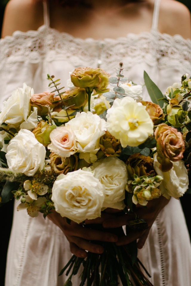 Красивый букет невесты с белыми розами в руках