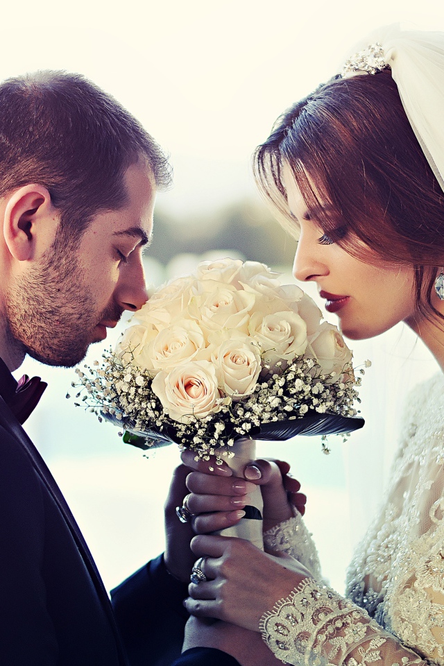 Жених и невеста с букетом белых роз 