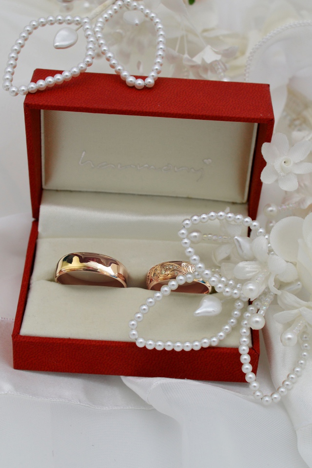 Золотые обручальные кольца в красной коробочке с украшениями