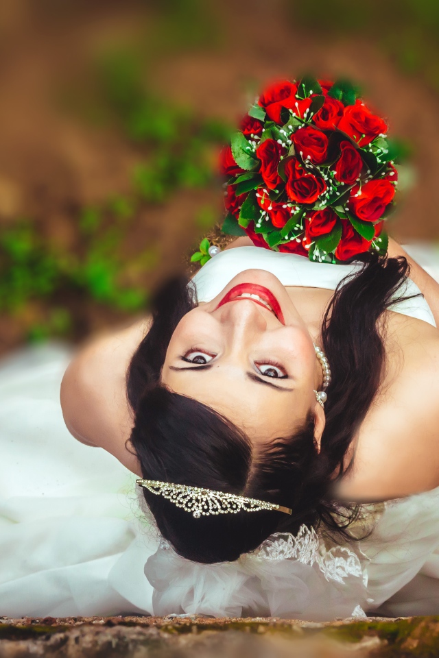 Улыбающаяся девушка невеста с букетом красных роз