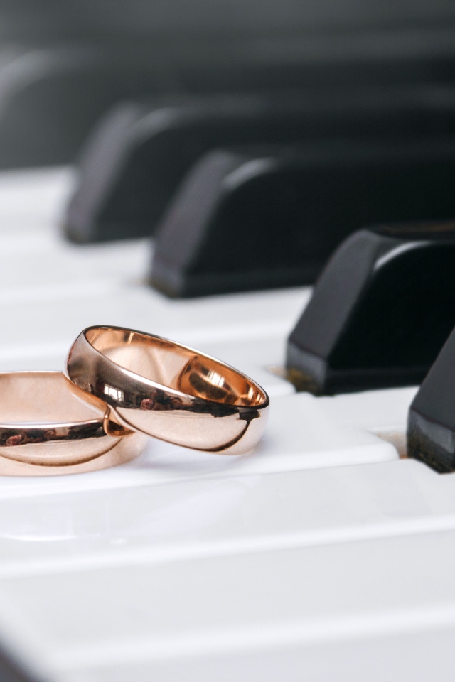 Two gold wedding rings on piano keys