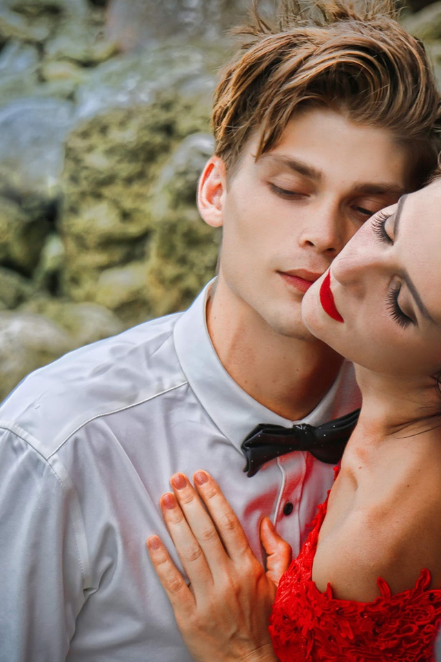 Красивая влюбленная пара стоит у камней