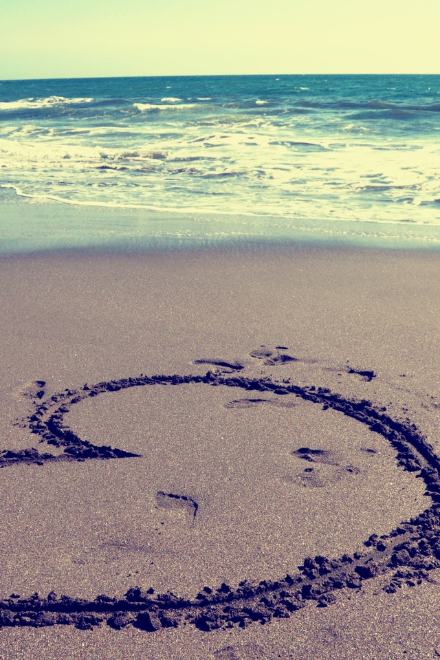 Большое сердце на мокром песке на пляже