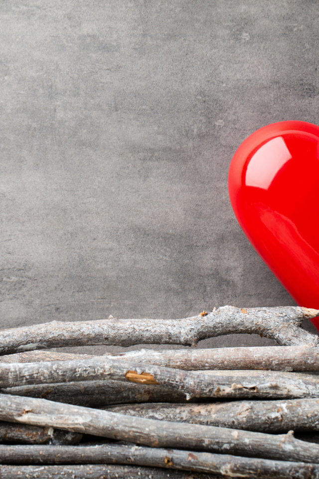 Большое красное сердце на сером фоне с деревянными прутьями