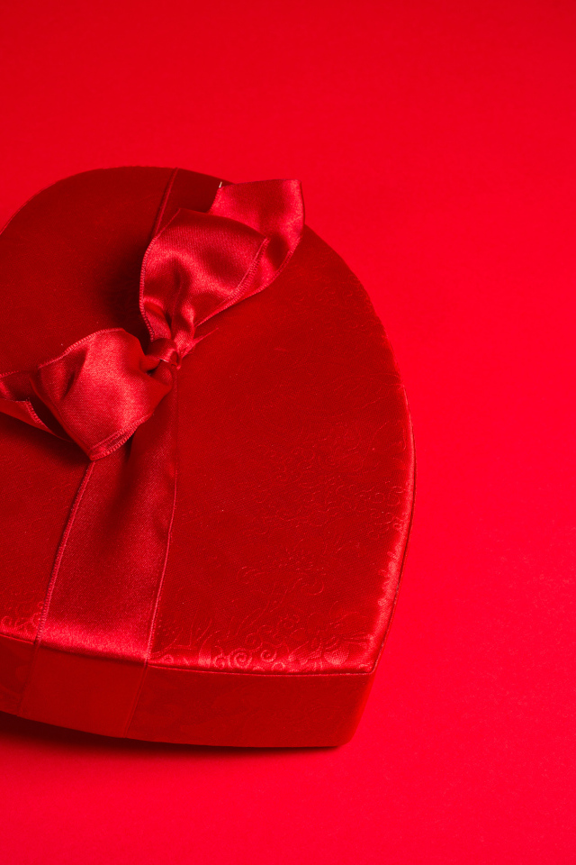 Большое красное сердце с бантом на красном фоне