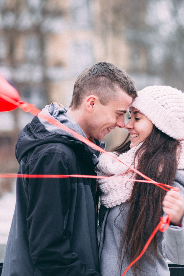 Влюбленная пара с воздушными шарами на улице зимой