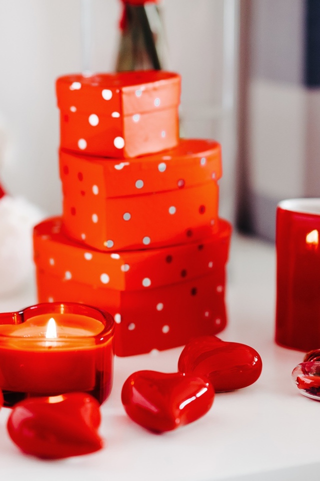 Чашка кофе на столе с подарками, зажженными свечами и сердечками