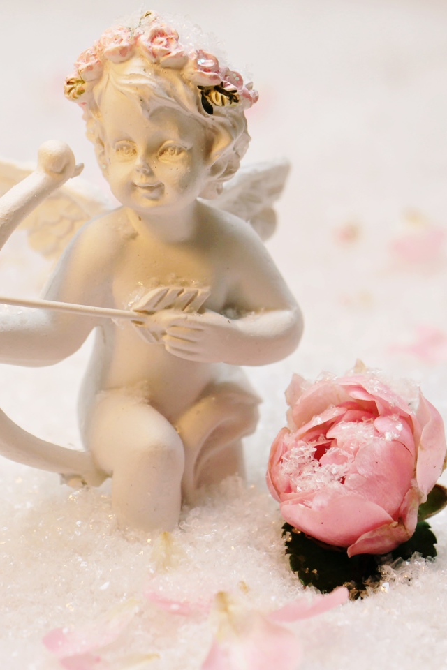 Статуэтка купидона с розой на снегу