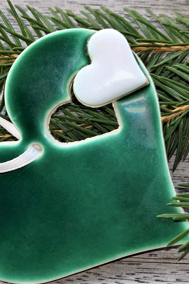 Зеленое сердце с еловой веткой на столе 