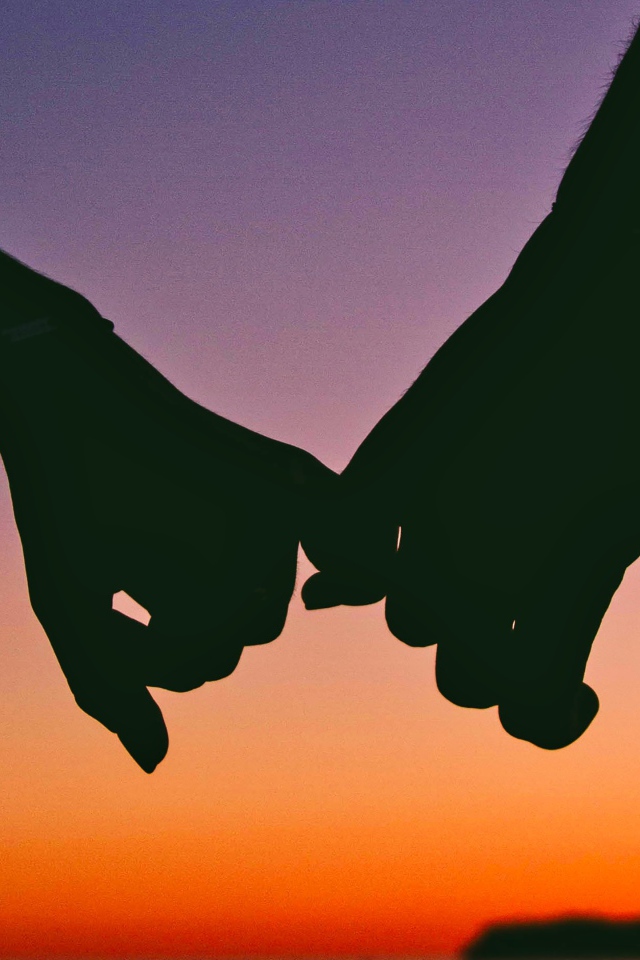 Руки влюбленной пары на закате солнца 