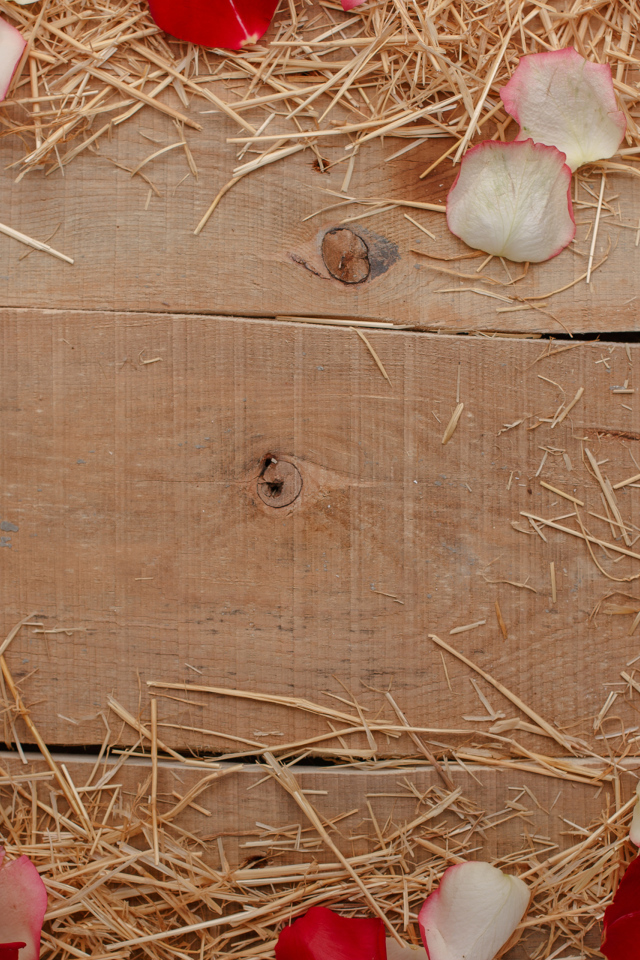 Сено и лепестки роз на деревянном столе 