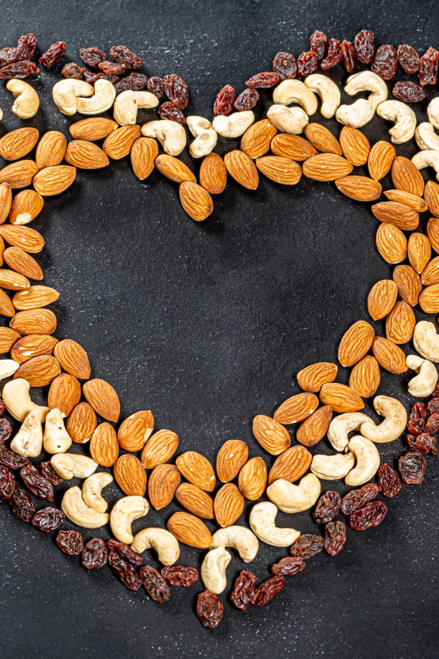 Сердце из орехов и изюма на сером фоне