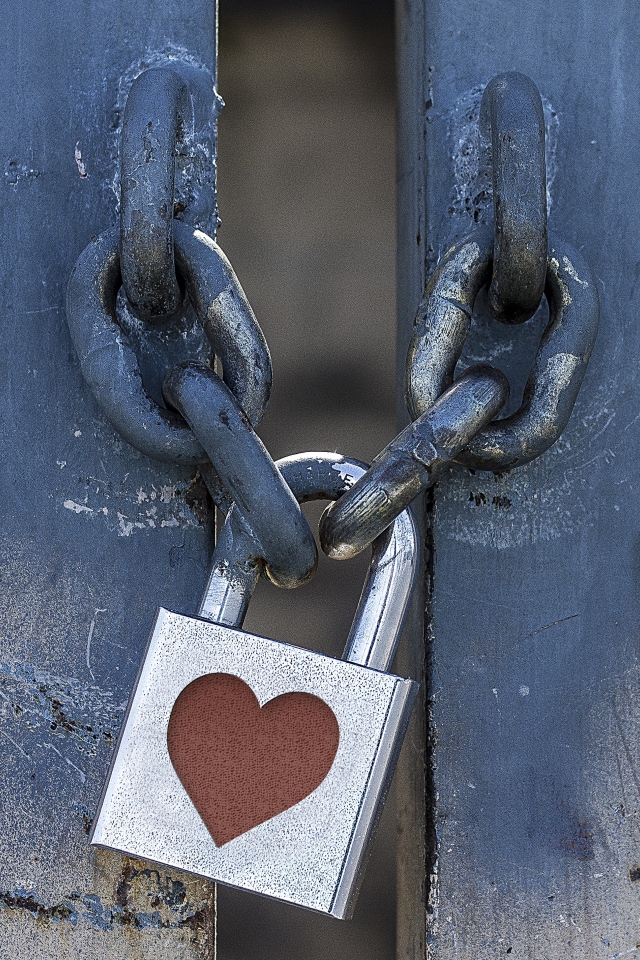 Железный замок с сердцем висит на цепи 