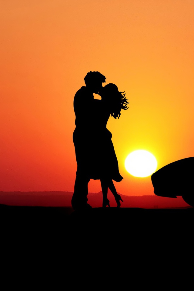 Kissing couple on sunset background with a car